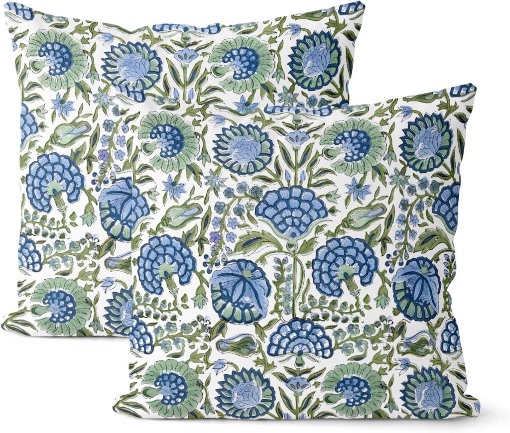 Two springtime throw pillows with a floral pattern in shades of blue and green on a white background. The design features large stylized flowers and leaves, creating a vibrant and elegant look.