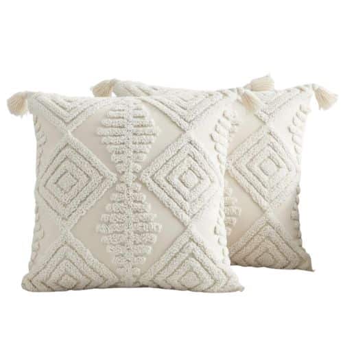 Two cream-colored amazon boho throw pillows with textured geometric diamond patterns and tassels on each corner, displayed against a plain white background.