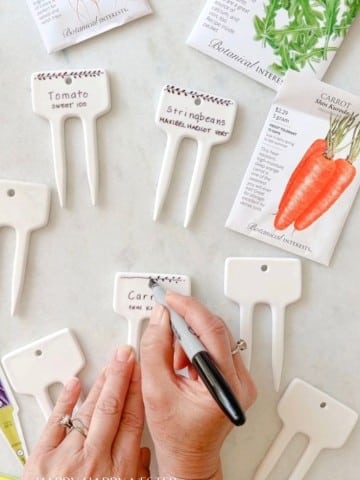 showing how to write on garden markers for your garden