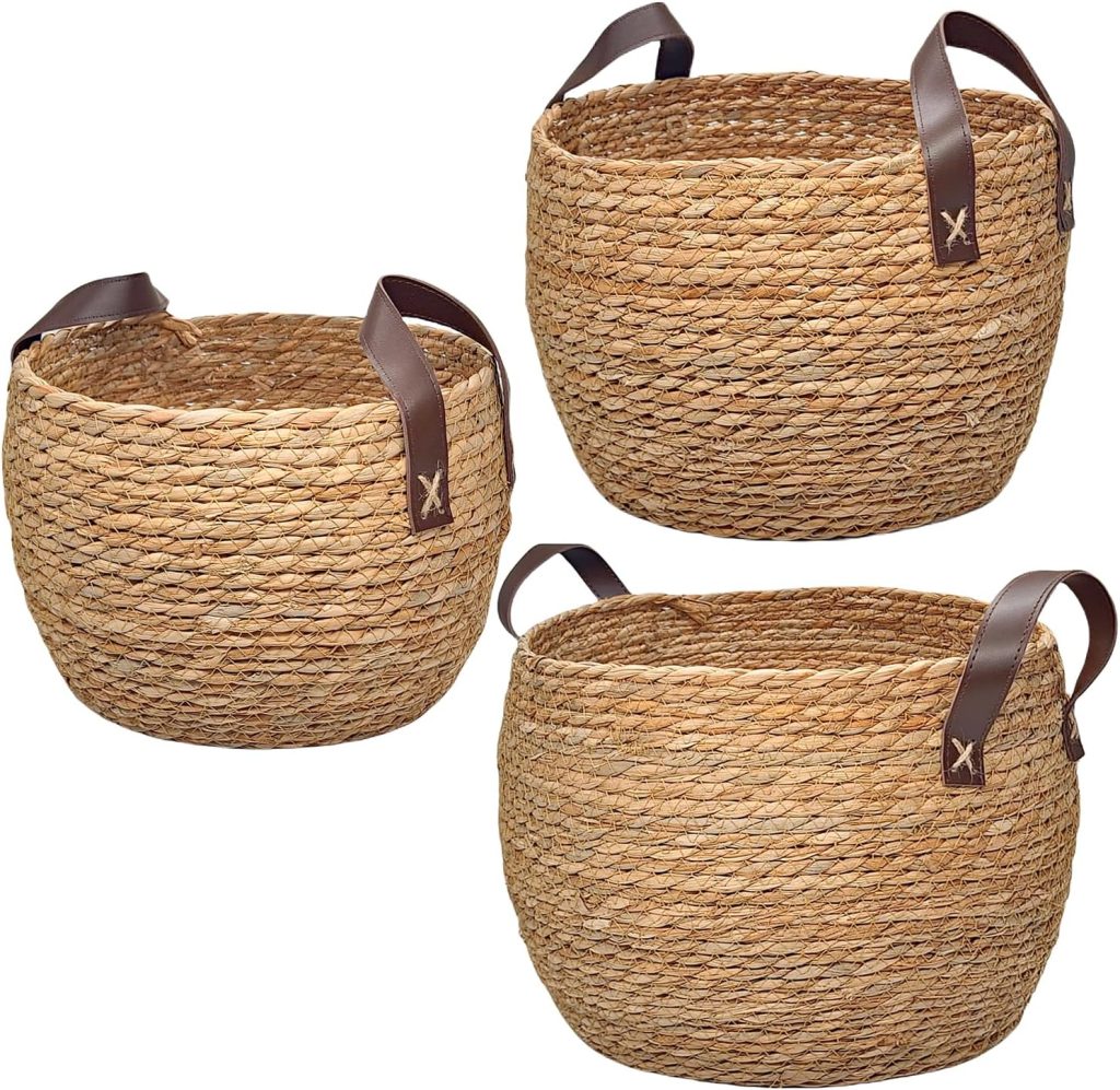 Three woven baskets with brown leather handles, made of natural fiber, displayed against a white background. Each round basket, varying in size, is perfect for organizing your space and inspiring rattan decor ideas.