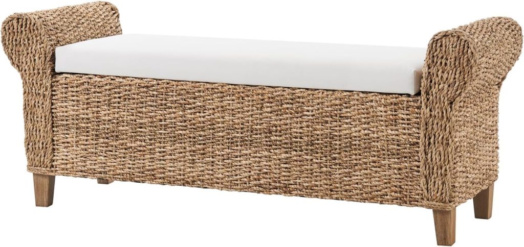 A woven wicker storage bench with short wooden legs, curved armrests, and a white cushioned seat—perfect for adding charm to your space and inspiring rattan decor ideas.