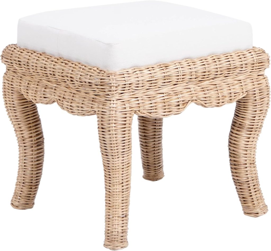 A small, square wicker stool with four curved legs and a white cushioned seat on top, perfect for adding to your rattan decor ideas.