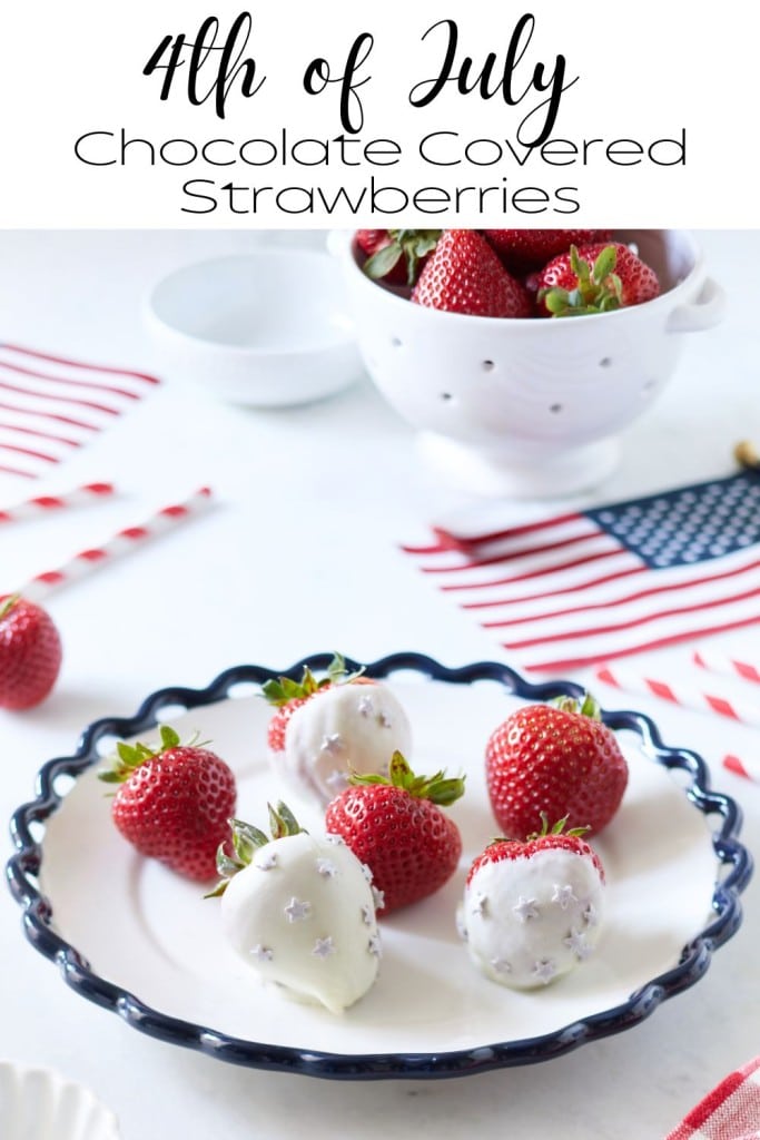A white plate with chocolate-covered strawberries is placed on a table. Some strawberries are plain, while others are dipped in white chocolate and decorated with silver stars. In the background, there's an American flag, a colander with strawberries, and a couple of straws.