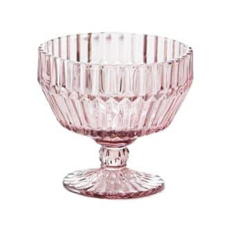 A small pink glass dessert bowl features a ribbed texture and a short, round pedestal base. The bowl has vertical lines that add an elegant, vintage touch, enhancing its decorative appeal.