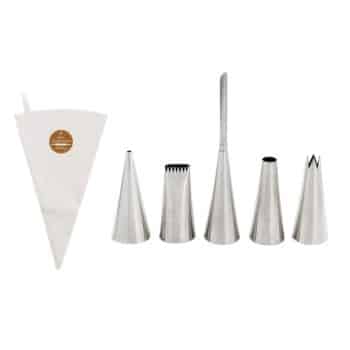 A set of cake decorating tools is displayed, including a reusable cloth pastry bag and five metal piping tips of various shapes and sizes. The tips are arranged in a row, showcasing their different designs for versatile icing applications.