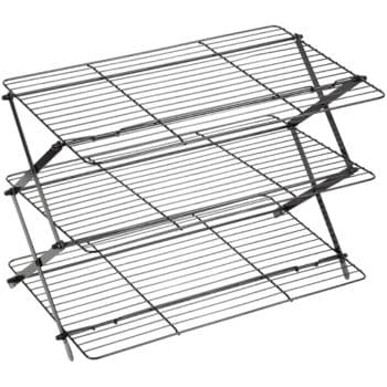 A black, three-tiered metal drying rack with wire grids and a collapsible design for easy storage. The rack is shown in an expanded position, ready for use.