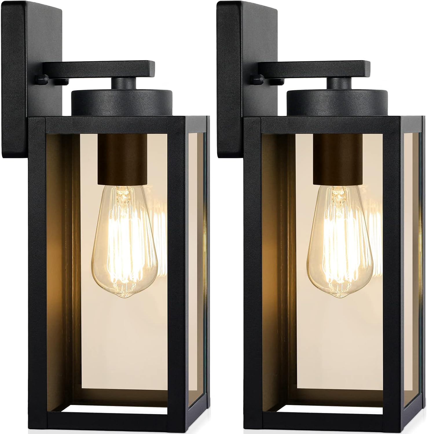 Two modern black metal and glass outdoor wall lanterns with exposed bulbs, mounted on rectangular backplates. Perfect for flower garden decor ideas and more, the lights are turned on, emitting a warm glow.
