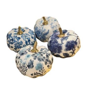 Four decorative white pumpkins featuring intricate blue floral designs, each with a gold-colored stem. The patterns vary from pumpkin to pumpkin, showcasing different floral motifs, including leaves and butterflies. The pumpkins are arranged in a group.