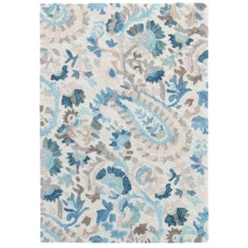 A rectangular area rug featuring an intricate floral and paisley pattern in shades of blue, gray, and white. The design is dense and detailed, with various swirls and leaves creating an ornate overall look.