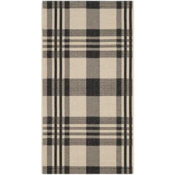 A rectangular rug featuring a classic plaid pattern in black and beige. The design consists of intersecting horizontal and vertical lines creating squares and rectangles in varying shades of these colors. The style is traditional and timeless.