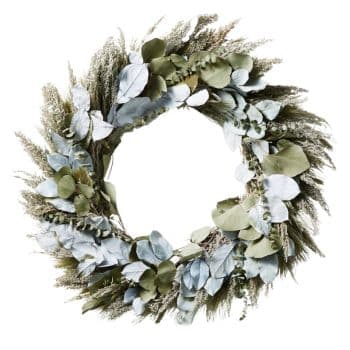 A circular wreath made from a mix of light green and silvery-blue eucalyptus leaves intertwined with various dried grasses and foliage, creating a natural and elegant decorative piece. The wreath has a soft, organic appearance with a slightly asymmetrical design.