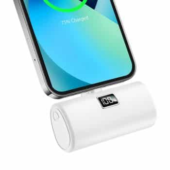 A white portable battery pack is attached to a smartphone. The phone's screen displays "75% Charged" with a green circular charging icon. The battery pack features a small digital display showing "100.