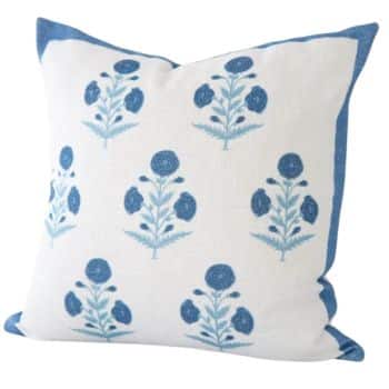 A white decorative throw pillow with a blue floral pattern. The pillow features a design of blue flowers and leaves arranged in a vertical pattern. The edges of the pillow are lined with blue fabric, adding a contrasting border.