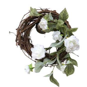 A rustic wreath made of intertwined brown twigs, decorated with white roses and green leaves, arranged naturally around its perimeter.