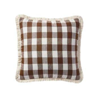 A square throw pillow with a brown and white buffalo check pattern. The pillow features a fringed trim around the edges. The design has a rustic and cozy appearance, suitable for home decor.