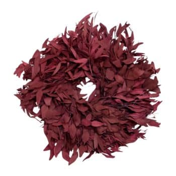 A circular wreath made of deep red leaves, creating a dense and textured look. The leaves are layered closely together, forming a full and vibrant arrangement.