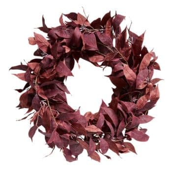 A circular wreath made of reddish-brown dried leaves. The leaves are arranged densely, creating a full and rustic appearance. The wreath has a natural and autumnal feel, suitable for seasonal decoration.