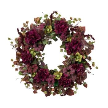 A circular floral wreath featuring an assortment of deep red and burgundy blooms, interspersed with green leaves and smaller accent flowers. The arrangement is lush with various textures, creating a rich and elegant appearance.