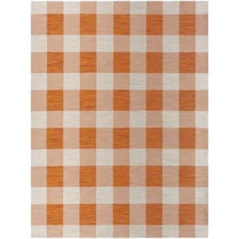 A rectangular rug featuring a large checkered pattern with alternating orange and beige squares. The checkered design is evenly distributed across the entire surface.