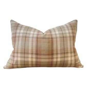 A rectangular throw pillow with a plaid pattern in shades of beige, brown, and cream. The pillow has a slightly overstuffed appearance with a distinctive V-shaped crease in the center.