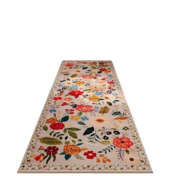 A beige rectangular runner rug with a colorful floral pattern, featuring red, yellow, and orange flowers interspersed with green and blue leaves. The rug has a decorative border with a subtle repeating design. The background is gradient and light in color.