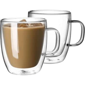 Two clear, insulated glass cups with handles. One cup is empty, and the other is filled with a creamy, iced beverage. The double-wall design of the glasses is evident, showing their durability and temperature retention feature.