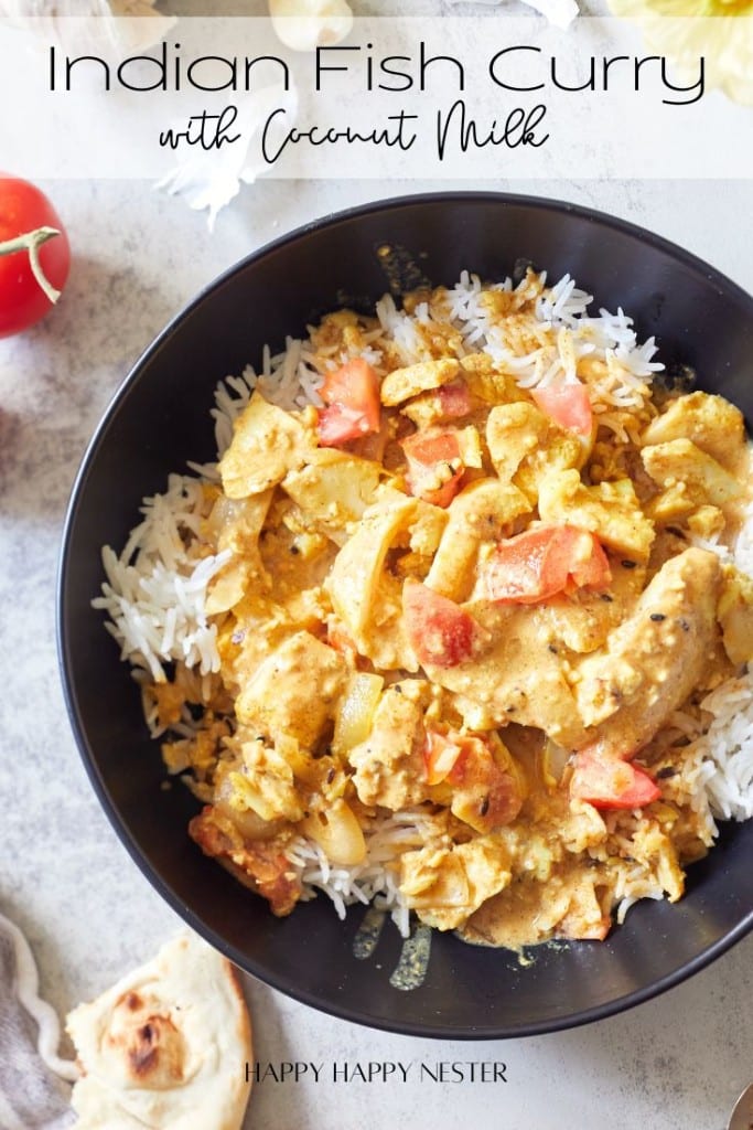 A bowl of Indian fish curry with coconut milk is served over white rice, garnished with diced tomatoes. A slice of naan bread and a cherry tomato can be seen in the background. The text "Indian Fish Curry with Coconut Milk" is displayed at the top.