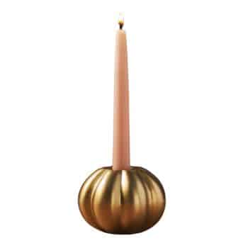 A lit, tall, pink taper candle is placed in a round, golden, pumpkin-shaped candle holder. The holder has a shiny, metallic finish with ridges, resembling a pumpkin's surface.