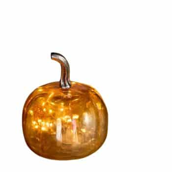 A decorative glass pumpkin with a shiny orange surface and a metallic silver stem. The surface reflects light, giving it a luminous and festive appearance. The pumpkin is centered with a plain white background.