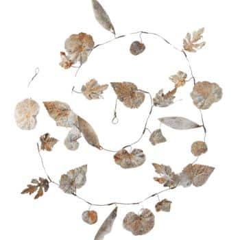 A circular wreath made of thin wire is adorned with a variety of dried leaves in different shapes and sizes. The leaves are predominantly brown and have a delicate, papery texture, giving the wreath a rustic, autumnal appearance.