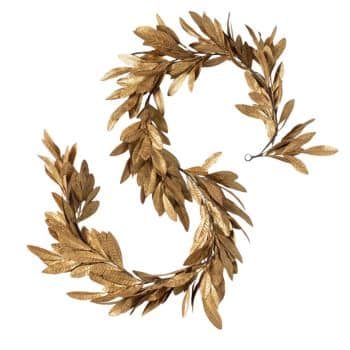 A gold laurel wreath in the shape of the letter "S" on a white background. The wreath is composed of metallic gold leaves that give it a textured and elegant appearance.