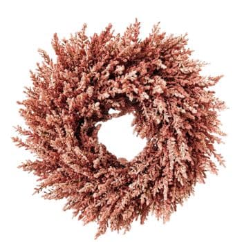 A top-down view of a circular wreath made from dried, pink-flowered branches. The branches are densely packed and extend outward, creating a full and textured appearance. The overall color of the wreath is a soft, dusty pink.