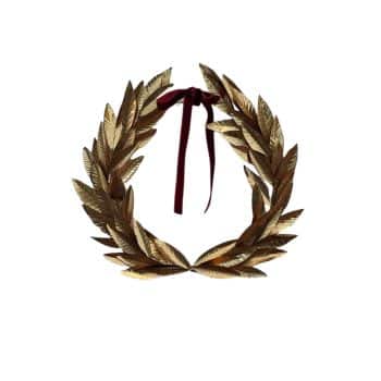 A gold laurel wreath, symbolizing victory or honor, with detailed leaves shaped into a circular crown. A dark red ribbon is tied into a bow at the top, adding contrast to the metallic sheen of the laurel. The design is set against a plain white background.