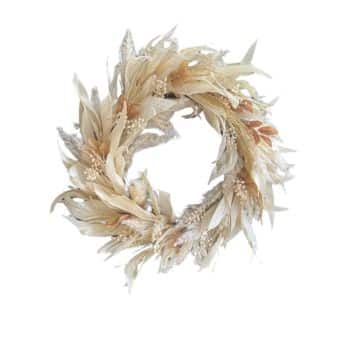 A circular wreath made of dried beige and light brown leaves and flowers arranged in a natural, flowing pattern. The wreath has a rustic, earthy appearance and is set against a white background.