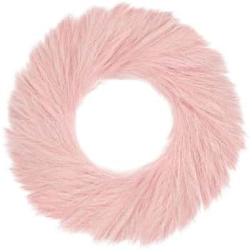 A round, fluffy, pink fur-like wreath with a soft, plush texture. The wreath has a hole in the center, making it resemble a donut shape.