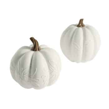 Two white ceramic pumpkins with embossed leaf designs on their surfaces. Each pumpkin topped with a metallic gold-colored stem. Both are displayed on a white background.