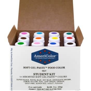 An open box of AmeriColor Soft Gel Paste Food Colors labeled "Student Kit" containing 12 assorted colors. Perfect for decorating autumn cookies, the bottles are arranged in two rows, with visible colors including pink, blue, green, orange, and yellow on the caps.