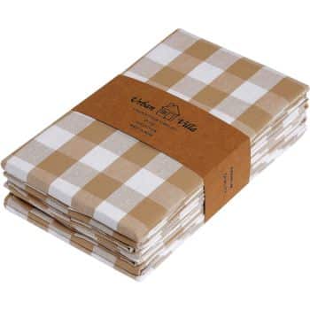 A stack of folded checkered kitchen towels, featuring a pattern of brown and white squares, neatly bound with a brown paper band labeled with branding and product information. Perfect for preparing your favorite autumn recipes, the towels appear clean and ready for use.