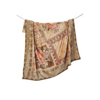 A colorful, patterned silk scarf is draped over a clothesline. The scarf features intricate floral designs and various shades of brown, pink, and cream. The edges of the scarf have a decorative border.