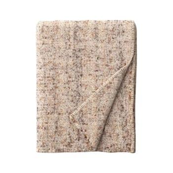 A beige and brown woven throw blanket, folded neatly with one corner slightly turned up, revealing the texture and pattern. The blanket has a soft and cozy appearance, with a blend of light and dark fibers interwoven across its surface.