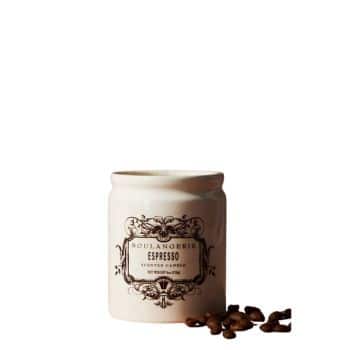 A white ceramic jar with "Boulangerie Espresso" written on it, featuring decorative vintage-style text. A few coffee beans are scattered beside the jar against a plain white background.