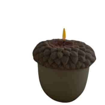 A candle shaped like an acorn with a realistic brown top and a flame burning at the wick, set against a plain white background.