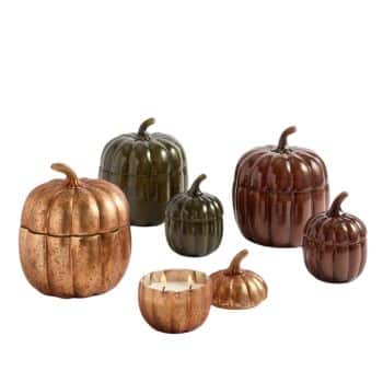 A collection of pumpkin-shaped containers in various sizes and colors, including bronze and green. Some have lids, and one is a candle holder. They are arranged on a plain white background.