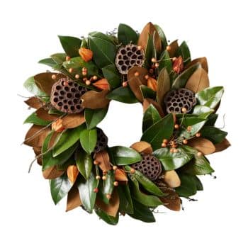 A green and brown wreath with magnolia leaves, dried lotus pods, and small orange berries.