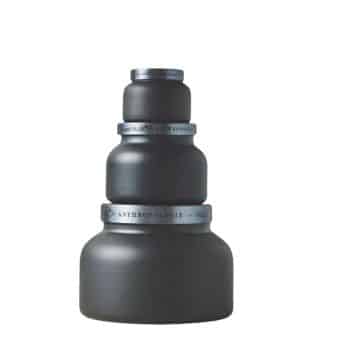 A tiered set of three matte black ceramic containers with silver bands, stacked to form a pyramid shape. Each container decreases in size from the base to the top, creating a visually balanced composition.