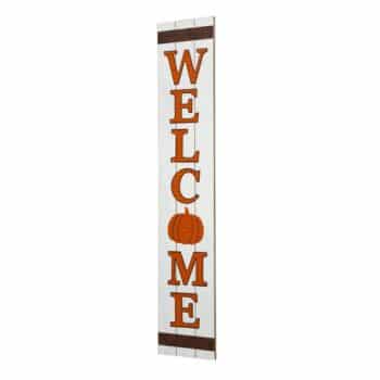 A vertical wooden sign with the word "WELCOME" in orange letters. The letter "O" is replaced by a pumpkin illustration. The sign has a rustic white background with dark brown borders at the top and bottom.