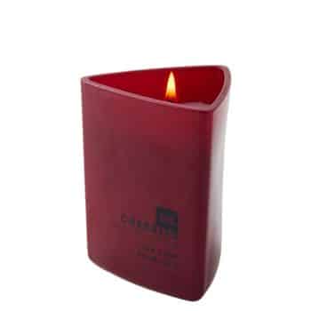 A red, triangular-shaped candle with a flame on top, featuring embossed text on its side.