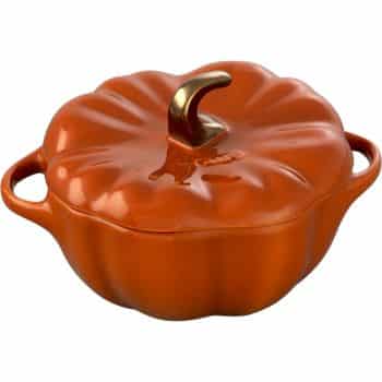 A pumpkin-shaped orange casserole dish with a lid, featuring a golden stem handle and two side handles. This ceramic piece, perfect for fall pies and cakes, is artfully designed to resemble a pumpkin.