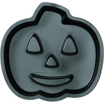 A pumpkin-shaped baking pan with indentations for eyes, nose, and a smile to create a jack-o'-lantern face. Perfect for crafting Halloween treats for kids, it's made of dark non-stick metal.