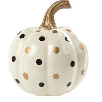 A white ceramic pumpkin with black and gold polka dots, featuring a metallic gold stem.